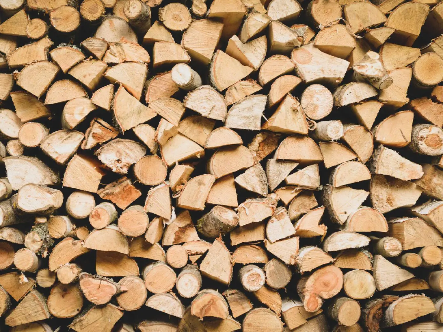 A stack of neatly arranged Firewood pieces displays diverse sizes and shades of brown.