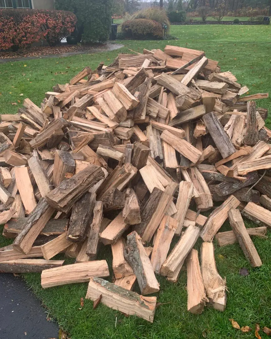A pile of wood sitting on top of the grass.