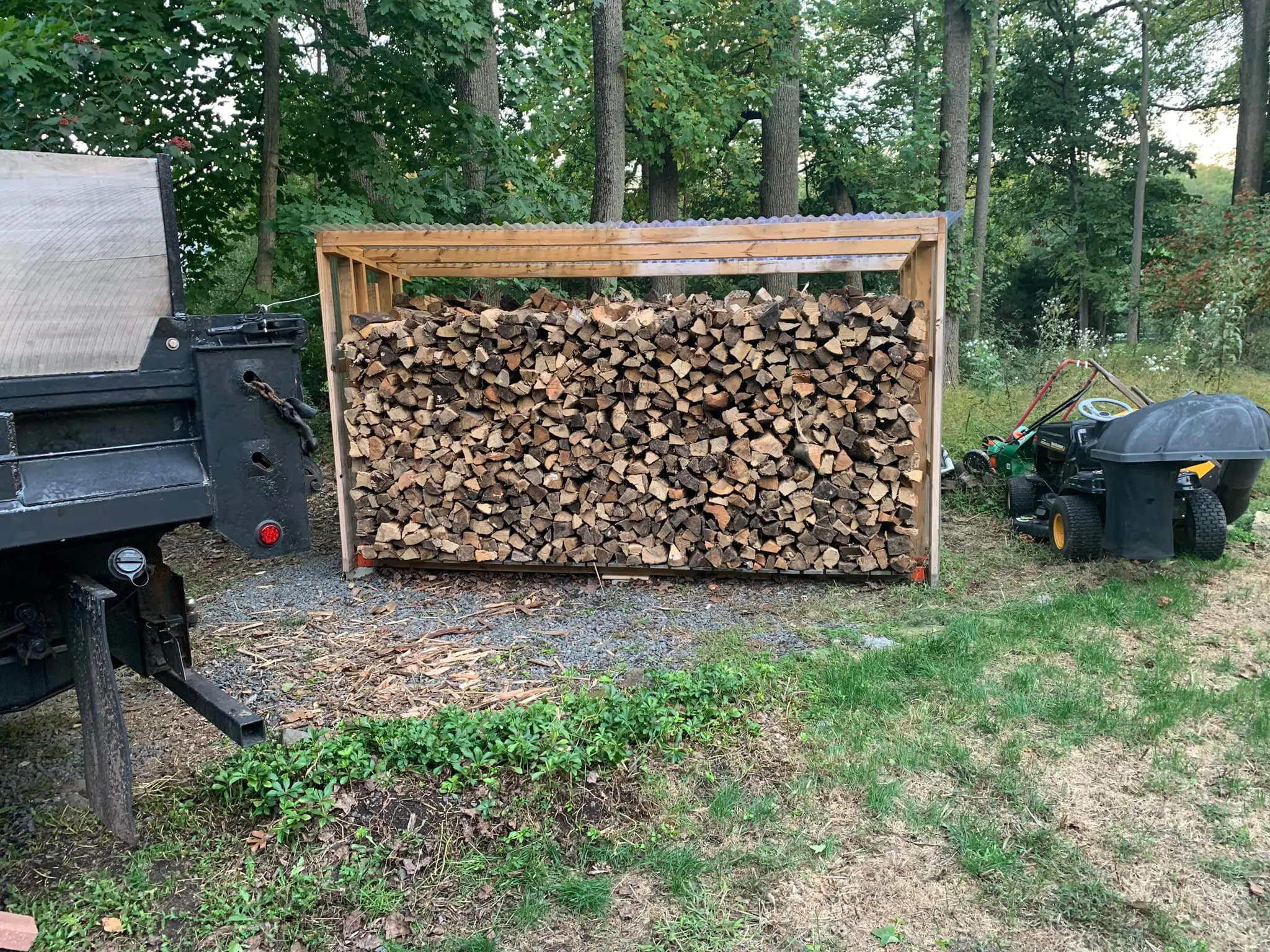 A wood pile with logs stacked on top of it.
