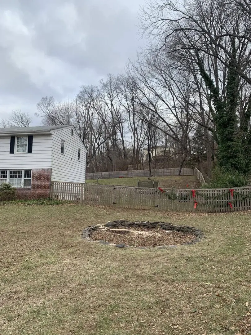 A fire pit in the middle of an empty yard.